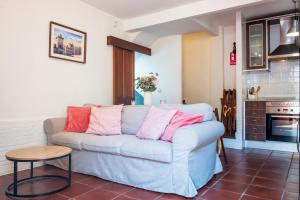 a living room with a white couch with pink pillows at El Cabildo in Piedralaves +12 photos