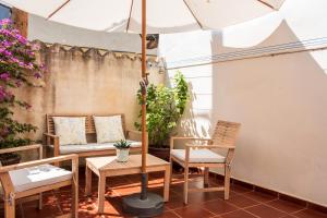 a patio with a table and chairs and an umbrella at El Cabildo in Piedralaves