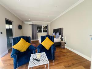 a living room with two blue chairs and a table at Vinorisa Spa & Lodge in Pretoria