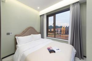a bedroom with a bed and a large window at 云深处江景公寓 in Chongqing