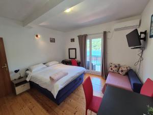 sypialnia z łóżkiem, telewizorem i kanapą w obiekcie Apartments Lampalo w mieście Okuklje