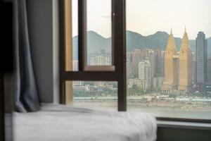 a view of a city from a bedroom window at 云深处江景公寓 in Chongqing