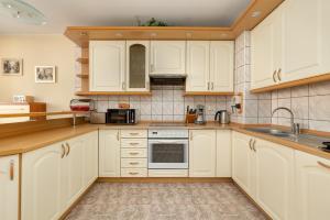 a kitchen with white cabinets and a sink at Central Port Giełdowa Apartment by Solarento in Kołobrzeg