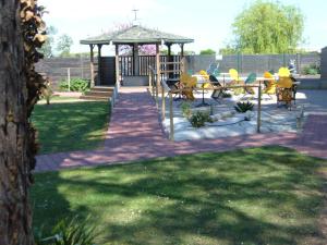 a gazebo with chairs and tables in a yard at Le Parasol in Ars-en-Ré