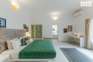a white bedroom with a large bed and a desk at Aroha Palms Luxury Villas in Mandrem +121 photos
