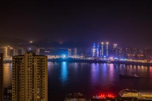 a view of a city at night with the water at 云深处江景公寓 in Chongqing