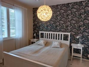 a bedroom with a bed and a chandelier at Kuukkeli in Kalajoki