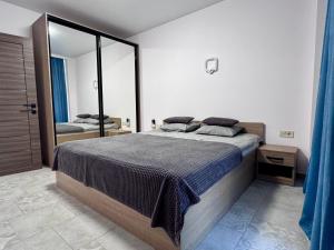 Un dormitorio con una cama grande y un espejo grande. en BUGAZ GOLD апартаменти біля моря, en Karolino-Buhaz