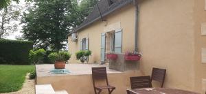 a patio with two chairs and a house at Gîte de campagne au cœur du Périgord à Rouffignac-Saint-Cernin-de-Reilhac in Rouffignac Saint-Cernin
