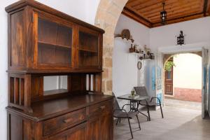 a large wooden cabinet in a kitchen with a table at Casa Tradizionale in Rhodes Town