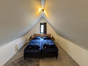a bedroom with two beds in a attic at Enkhuizer Strand BeachHouse Deck Acht mit Zaun Nr 408 in Enkhuizen