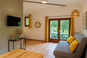 a living room with a couch and a table at village vacances du camboussel in Brassac