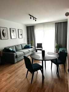 a living room with a table and chairs and a couch at PURA Vida in Gdynia