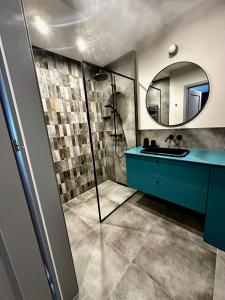 a bathroom with a blue sink and a shower at PURA Vida in Gdynia