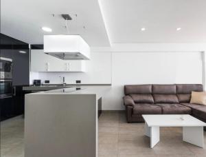 カルプにあるRIURAU HOME - 1ª línea CalpeMarのソファとテーブルのあるキッチンとリビングルーム