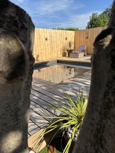 a backyard with a swimming pool and a wooden fence at Le Gite Hector in Carcassonne