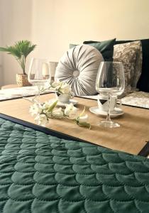 - une table avec 2 verres à vin et des fleurs dans l'établissement Elite Home 1 Jeżyce- Barańczaka 1, à Poznań