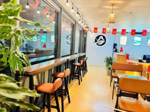 a restaurant with a bar with stools and tables at BBnB Home RESIDENCE in Quy Nhon