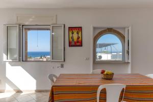 Un comedor con mesa y vista al mar. en Villetta Orizzonte vista mare, en Patù