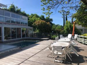 a deck with a table and chairs next to a pool at Villa Prune 200m 5 chambres avec piscine et garage in Aix-les-Bains