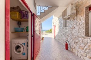 Una lavadora y secadora en un edificio con una pared de piedra en Villetta Orizzonte vista mare, en Patù