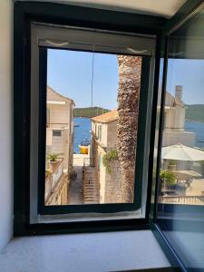 a window with a view of the water from a house at Slatki kut in Vis