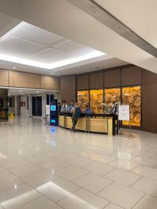 a lobby with a counter in a building at Shell Residences MOA by Kirstie in Manila