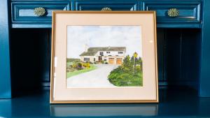 a painting of a house in a blue wall at Hidden Acres-Deluxe Double Room in Malahide +24 photos