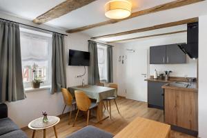 a kitchen and living room with a table and chairs at Zeihäänger Stubb in Schwalmstadt