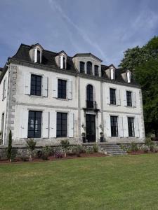 a large white building with a black roof at Chateau Forest in Arette