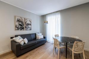 a living room with a black couch and a table at Residenza Le Terrazze in Alassio