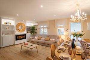 a living room with a table and a couch at Luxury Villa Paraiso Alicante - Piscina Salada Climatizada, Chimenea, gymnasio, despacho, Fútbol , Golf , BBQ , Netflix in Rebolledo