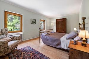 a bedroom with a bed and a chair and a window at Eco Farm La Cavallina in Affi +42 photos