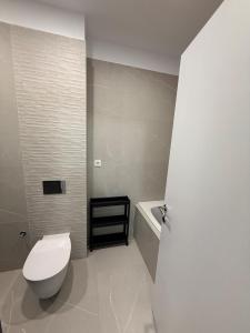 ein Badezimmer mit einem weißen WC und einer Badewanne in der Unterkunft Walter Loft Luxury Residence- Self Check-in & Underground Parking in Bukarest + 26 Fotos