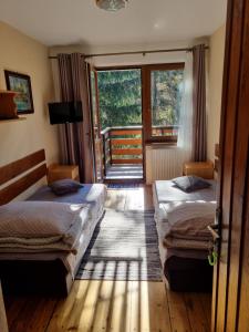 - une chambre avec 2 lits et une fenêtre avec vue dans l'établissement Kwatery u Janka, à Zakopane