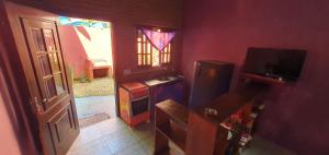 a room with a room with a door and a television at Tahoma Chalé Rustico Lila Prumirim in Ubatuba