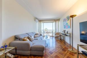 a living room with a couch and a tv at Palais D'orient in Nice