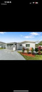 ein großes weißes Gebäude mit einer Einfahrt davor in der Unterkunft Newly Renovated Home on Canal - Fishing and boating friendly in North Fort Myers