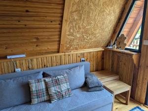 a blue couch in a room with a window at A Pine vikendica u srcu Zapadne Srbije in Nova Varoš