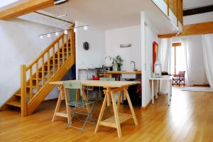 a living room with a table and a staircase at Le loft de Saint-Laurent in Saint-Laurent-le-Minier