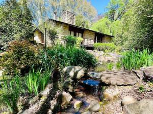 a house with a pond in front of it at Glentowy Farm Underberg in Underberg