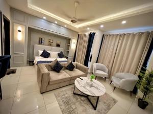Una sala de estar con una cama, un sofá y una mesa. en Gold Crest Luxury Premium Serviced Apartment DHA - Phase 4 Lahore LMY, en Lahore