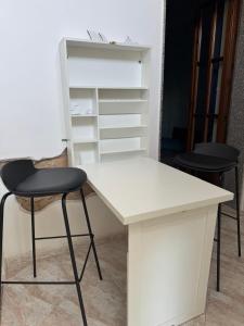 a white desk with two chairs and a shelf at Camera Giessealghero in Alghero