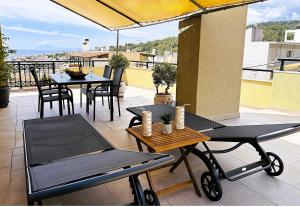 a patio with tables and chairs on a balcony at Rooftop Guesthouse in Kavála