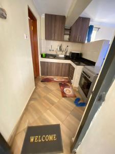a view of a kitchen with a welcome sign on the floor at Lowell Stays in Nairobi