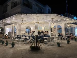 a group of people sitting at tables in a building at Calypso Hotel in Leipsoi