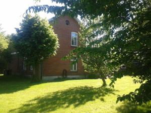 a brick house with a tree in front of it at Ferienwohnung Alter Dorfkrug 2 in Kronsgaard