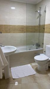 een badkamer met een bad, een toilet en een wastafel bij Appartement Playa de Tanger/ Marina Bay in Tanger