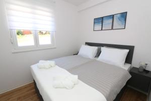 une chambre avec deux lits avec des serviettes dessus dans l'établissement Dolphin view II with a pool by the beach, à Mandre