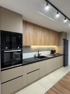 a kitchen with black appliances and wooden cabinets at Luma Apartment in Bitola